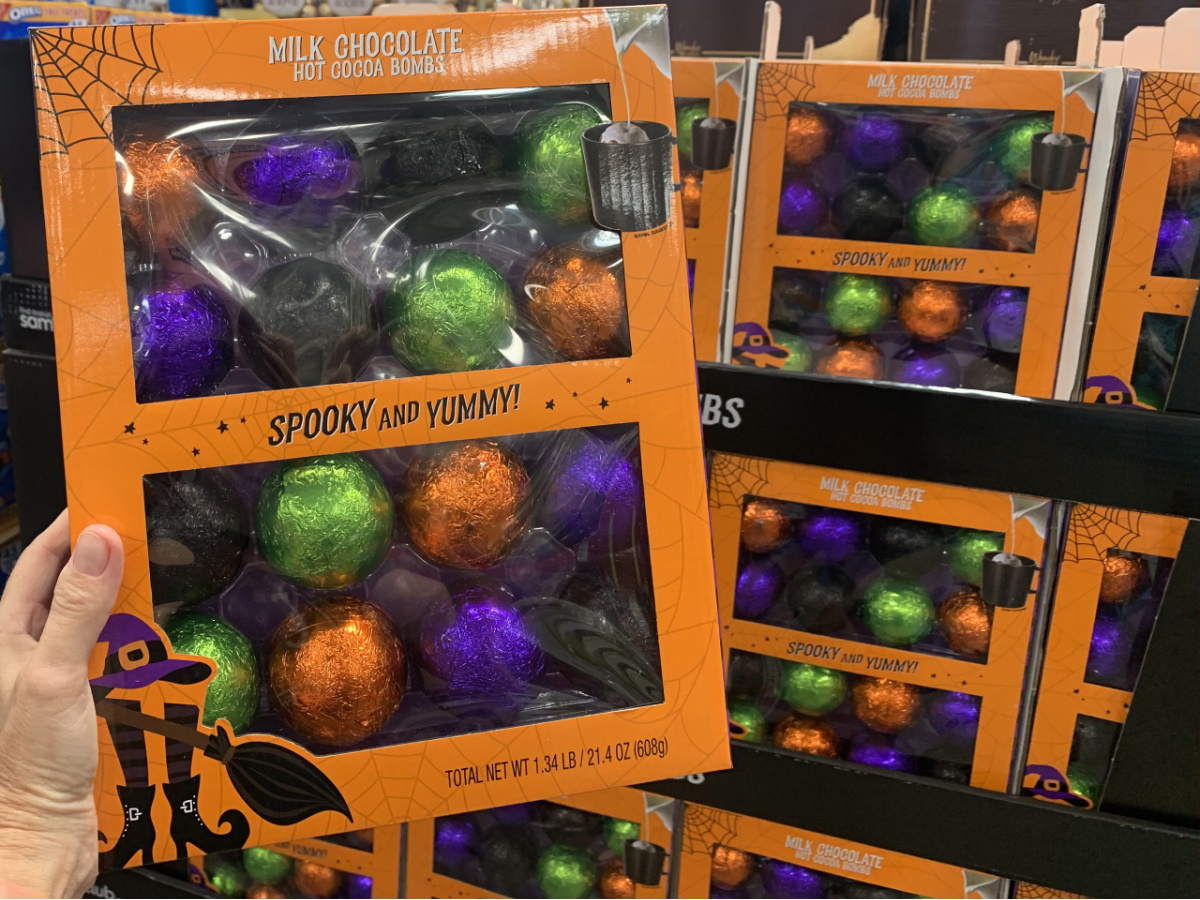 hand holding a halloween package of hot cocoa bombs in front of a store display