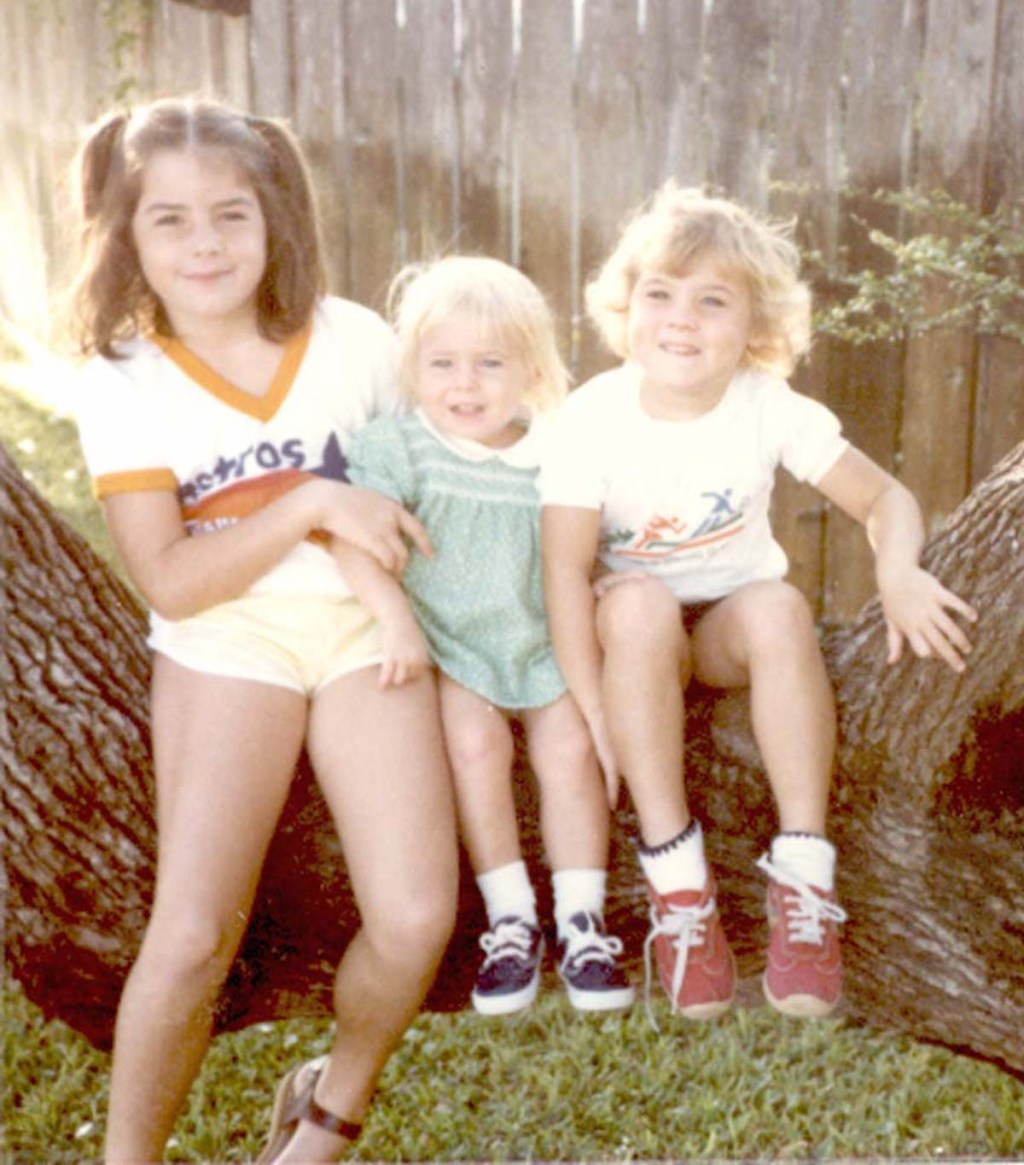 old picture of three kids sitting on tree