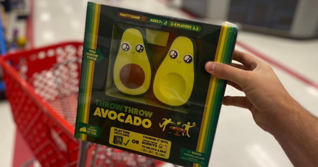 hand holding board game with an avocado on front 
