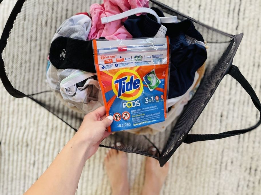 lady holding tide pods in front of her laundry