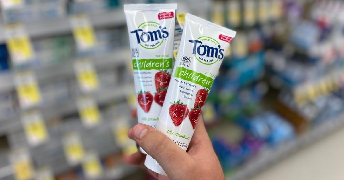 hand holding two tubes of Tom's of Maine Kids Toothpaste