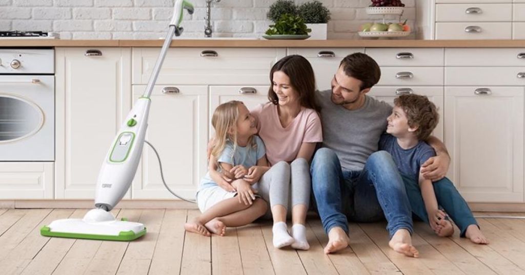 family sitting on kitchen floor next to steam mop