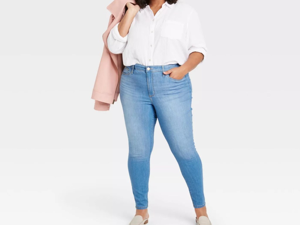 woman with pink jacket wearing shirt and jeans
