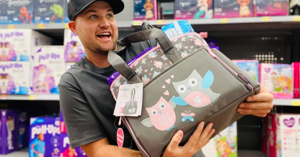 man holding a bronw diaper bag filled with diapers