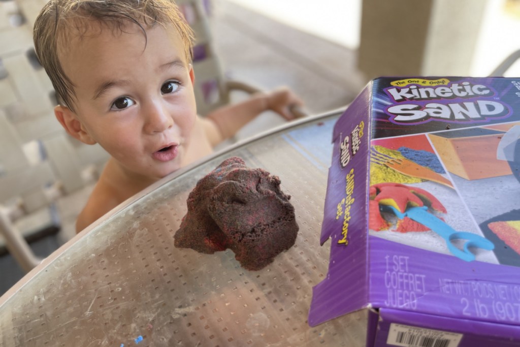 baby playing with kinetic sand outside