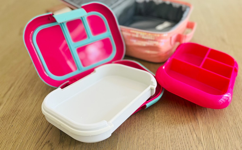 pink bentgo bento lunchbox with gray ice pack insert sitting on wood table