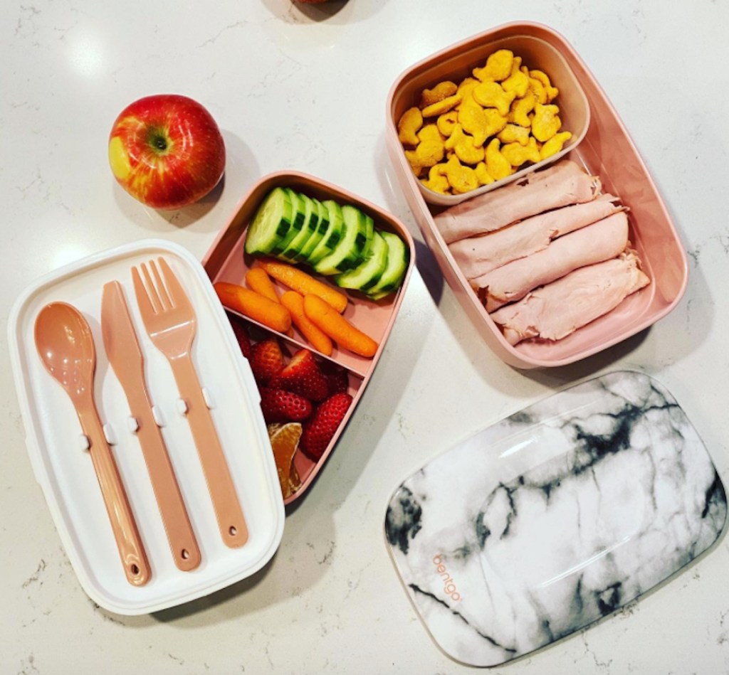 bento box on countertop with silverware and food inside