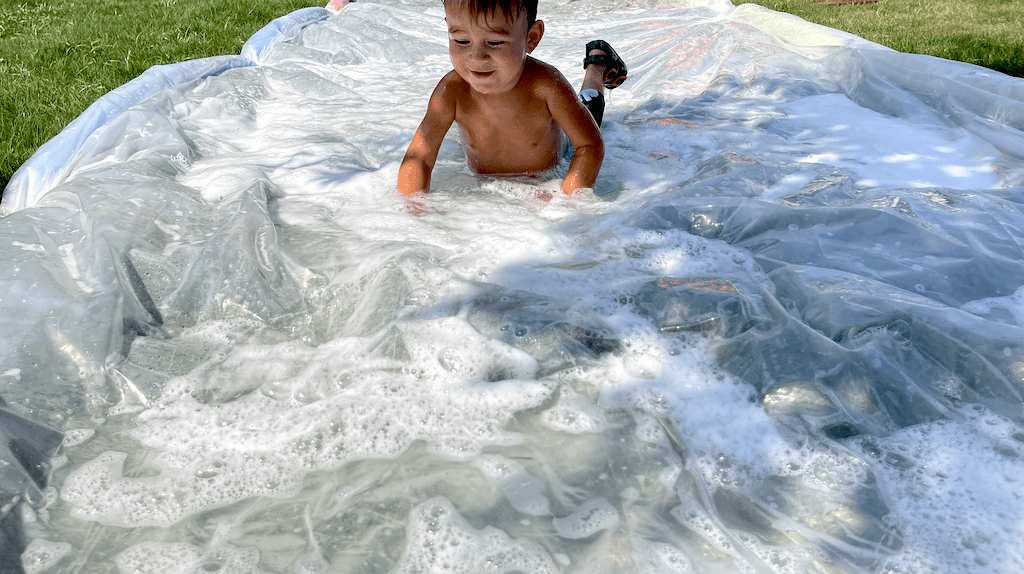little boy on DIY slip and slide 