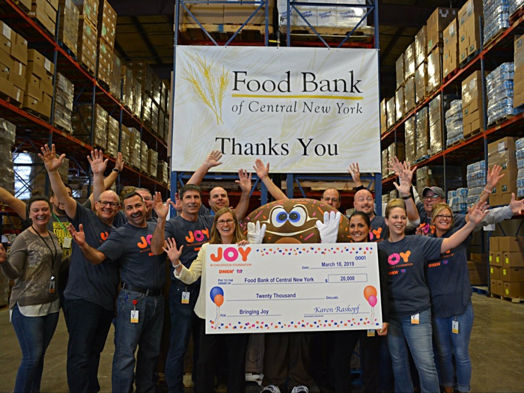Dunkin' workers holding a big check for charity
