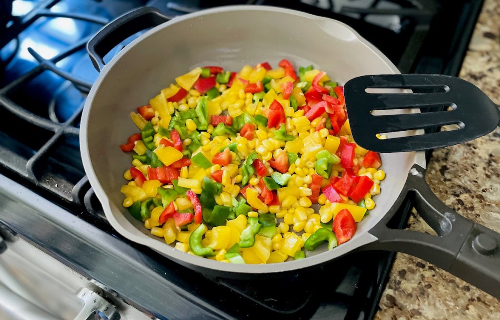 colorful peppers and corn in saute pan on stove
