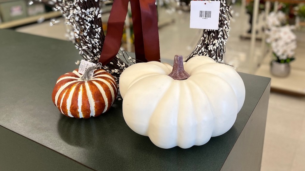 white and orange stripe pumpkins on green countertop in store