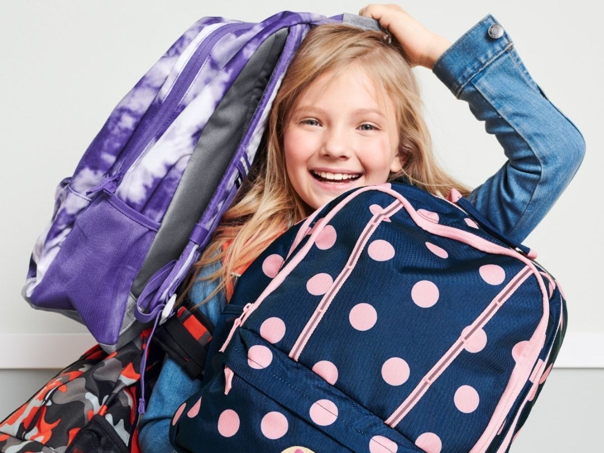 girl holding different backpacks