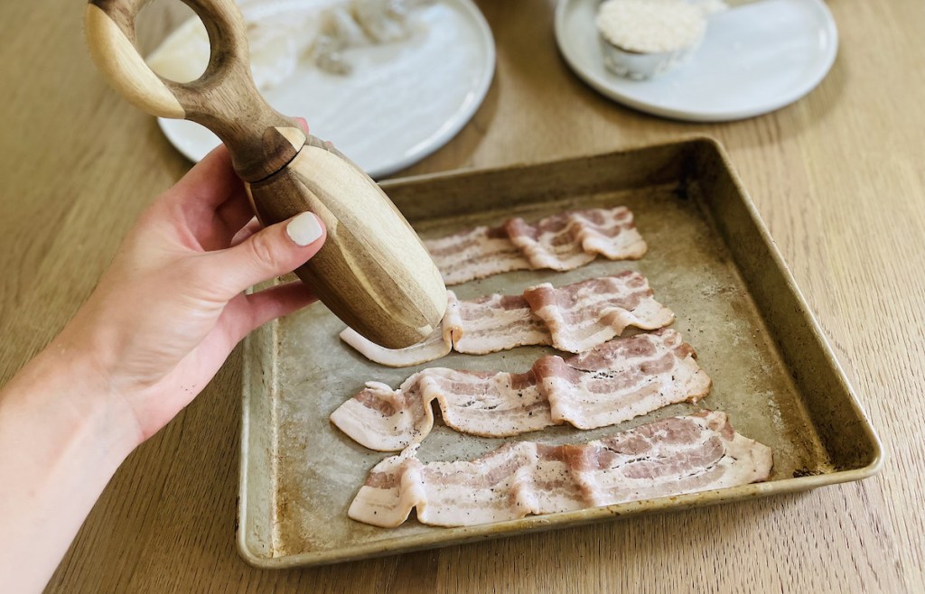adding pepper to raw bacon