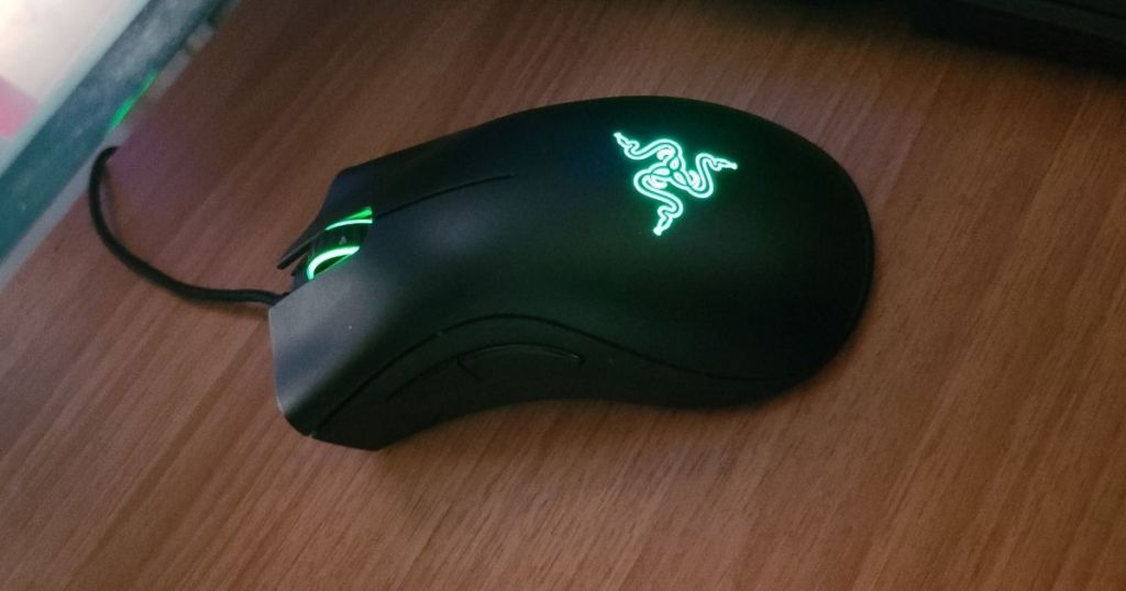 black gaming mouse on wood surface