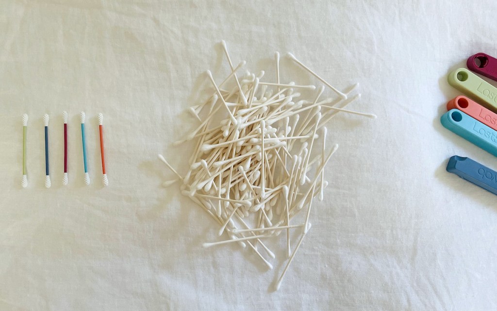 pile of cotton swabs on white sheets next to row of reusable q tips