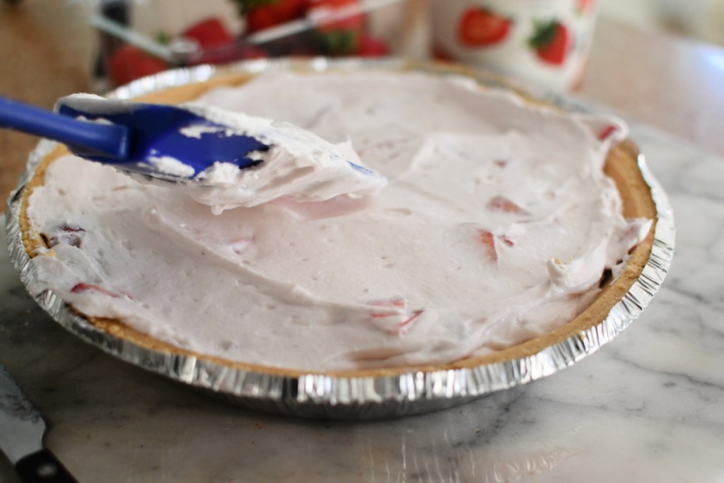 spreading a yogurt pie in a pie crust