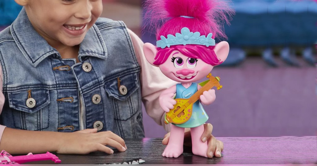 girl playing with trolls poppy doll