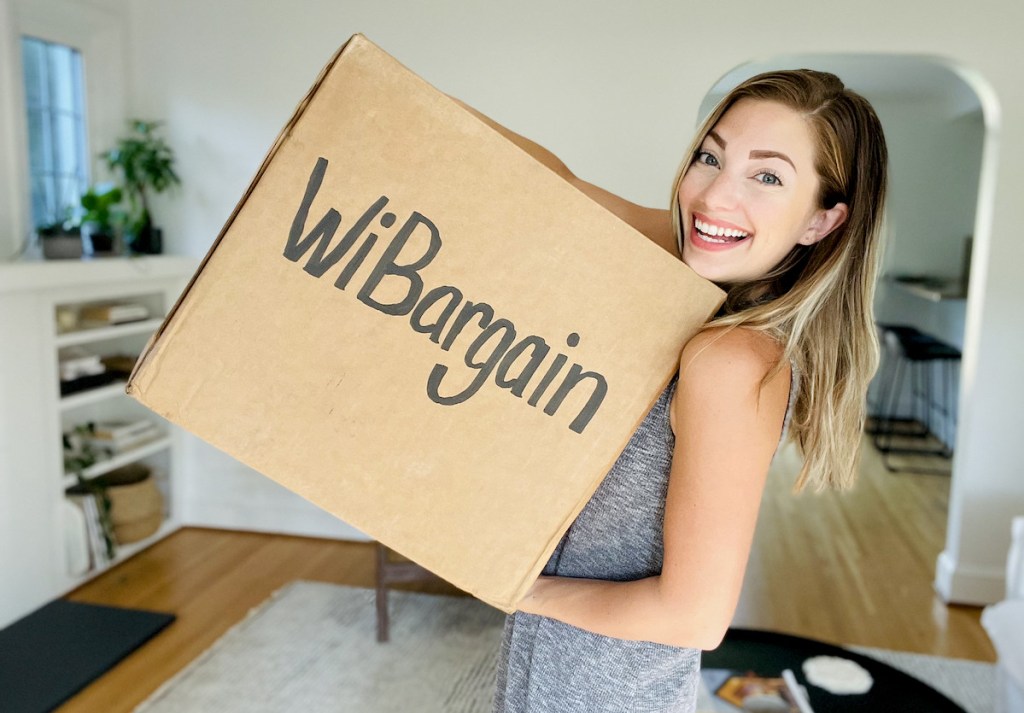 woman holding brown box with wibargain on front