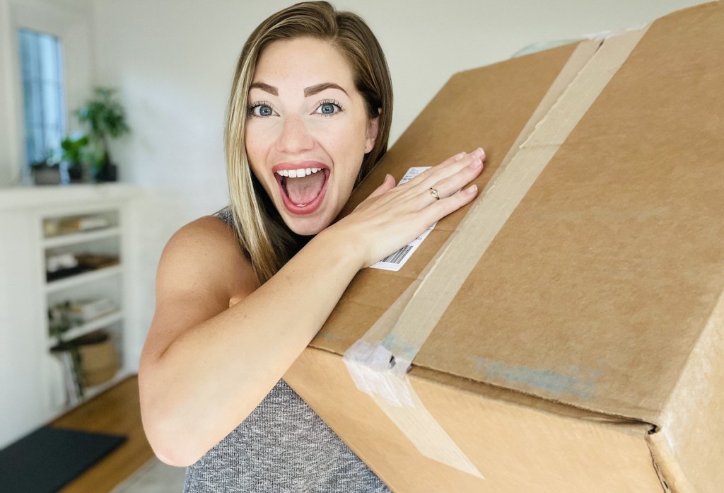woman holding delivery box with mouth open 