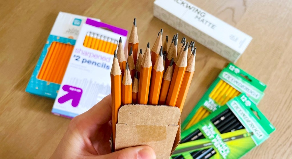 hand holding a box of wood pencils