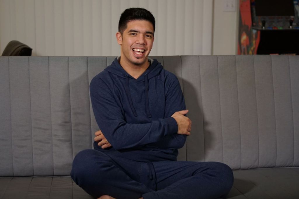 man sitting on a couch and smiling at the camera