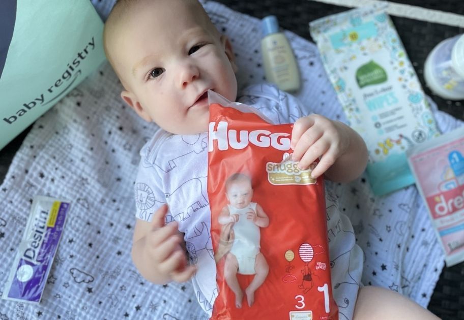 baby holding a sample of diapers