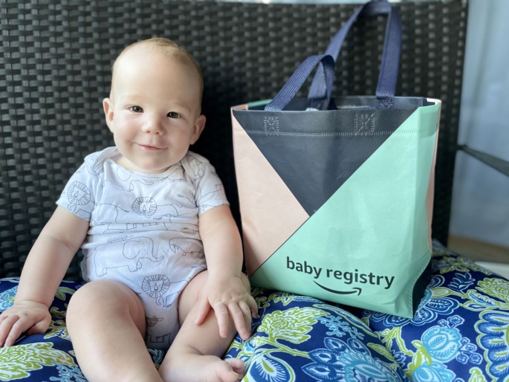 baby sitting next to an Amazon Baby Registry bag