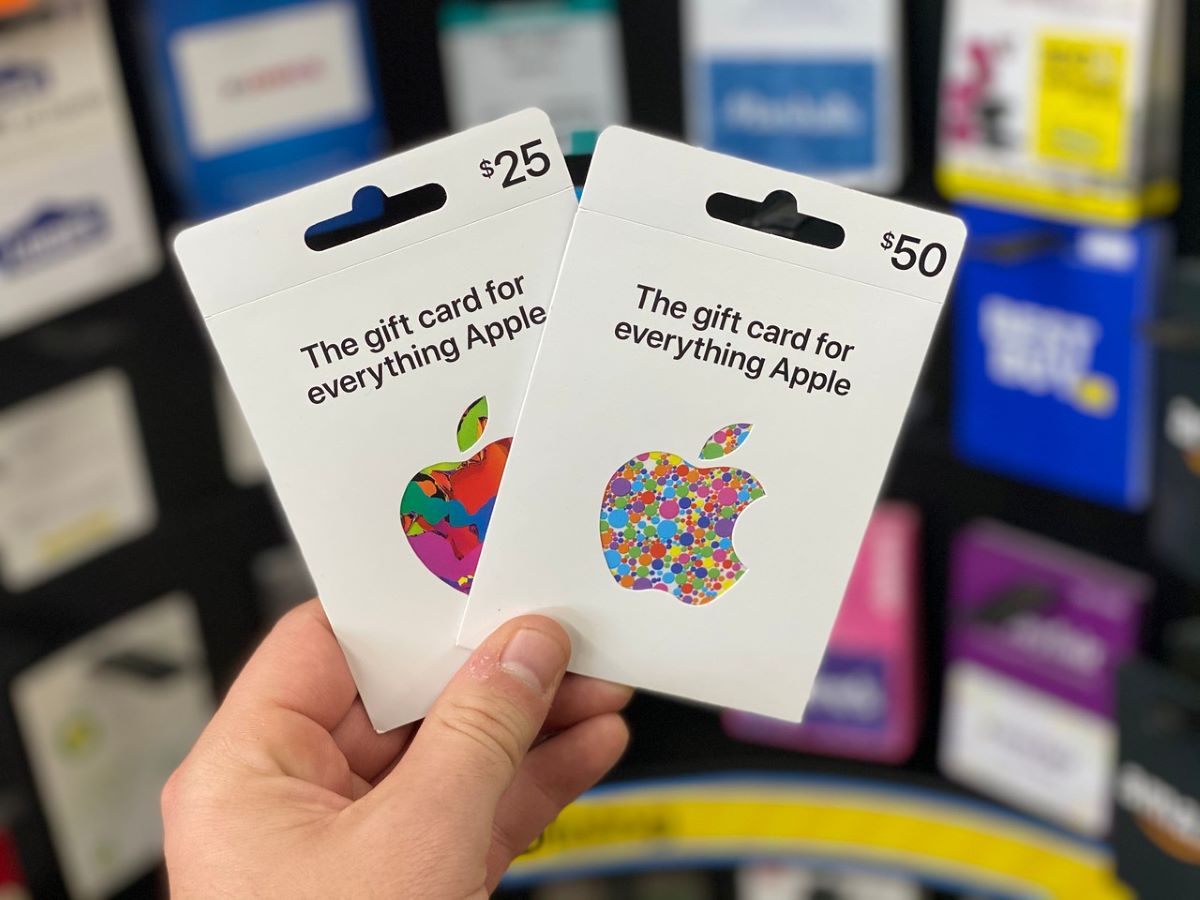 hand holding two Apple gift cards