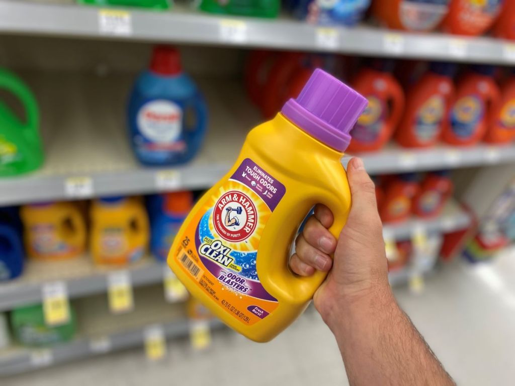hand holding a bottle of Arm & Hammer laundry detergent