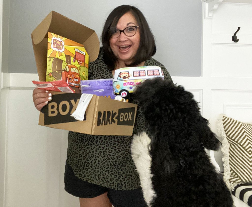 woman holding barkbox with dog jumping on her