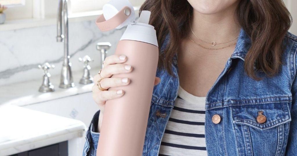 woman holding a pink water bottle