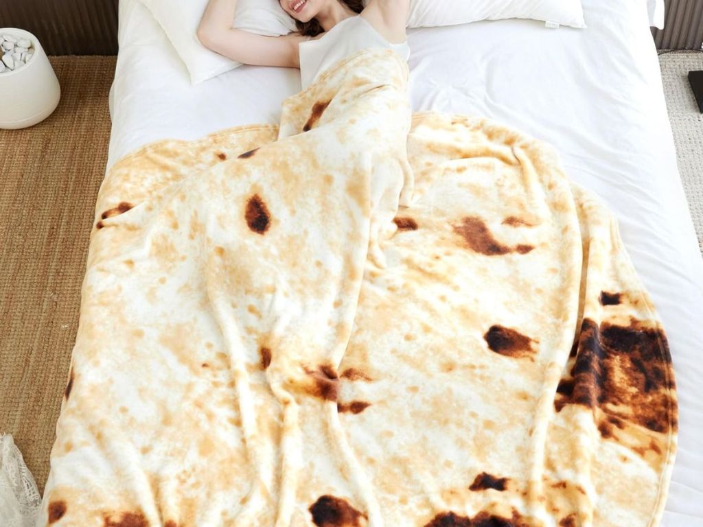 woman laying in bed with a burrito blanket
