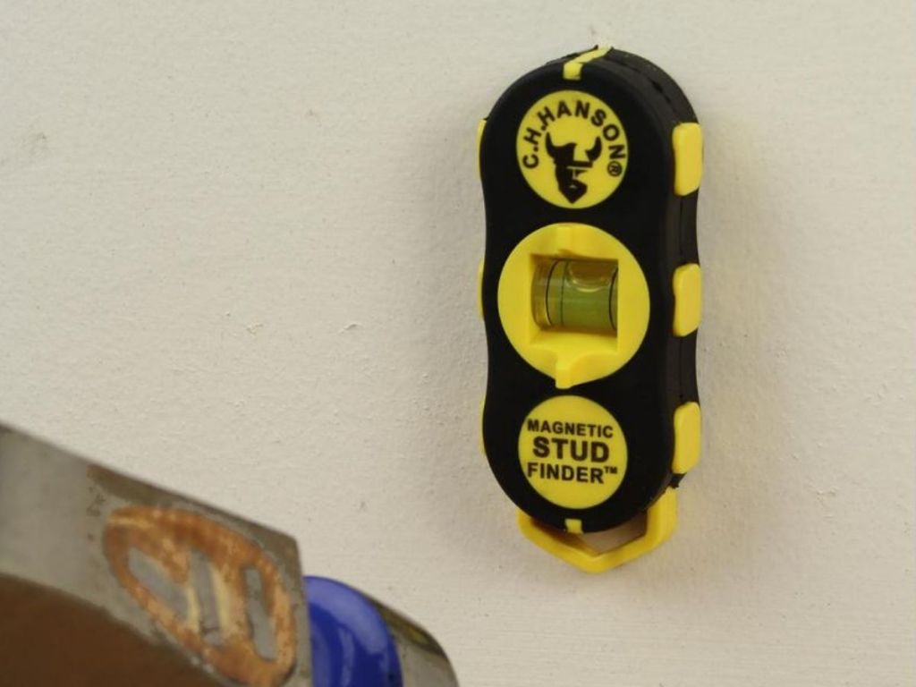 magnetic stud finder stuck to wall