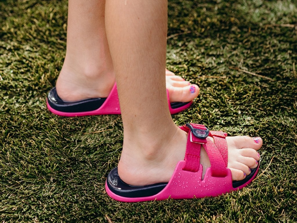 girl wearing pink slides in grass