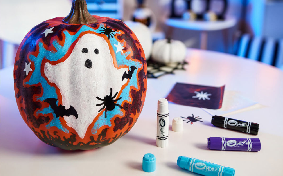 decorated pumpkin and paint sticks on table