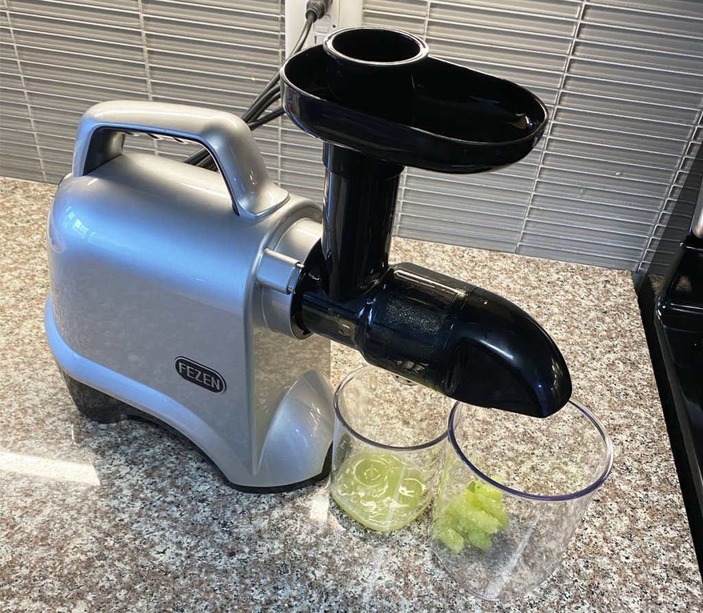 juicer on counter making green juice