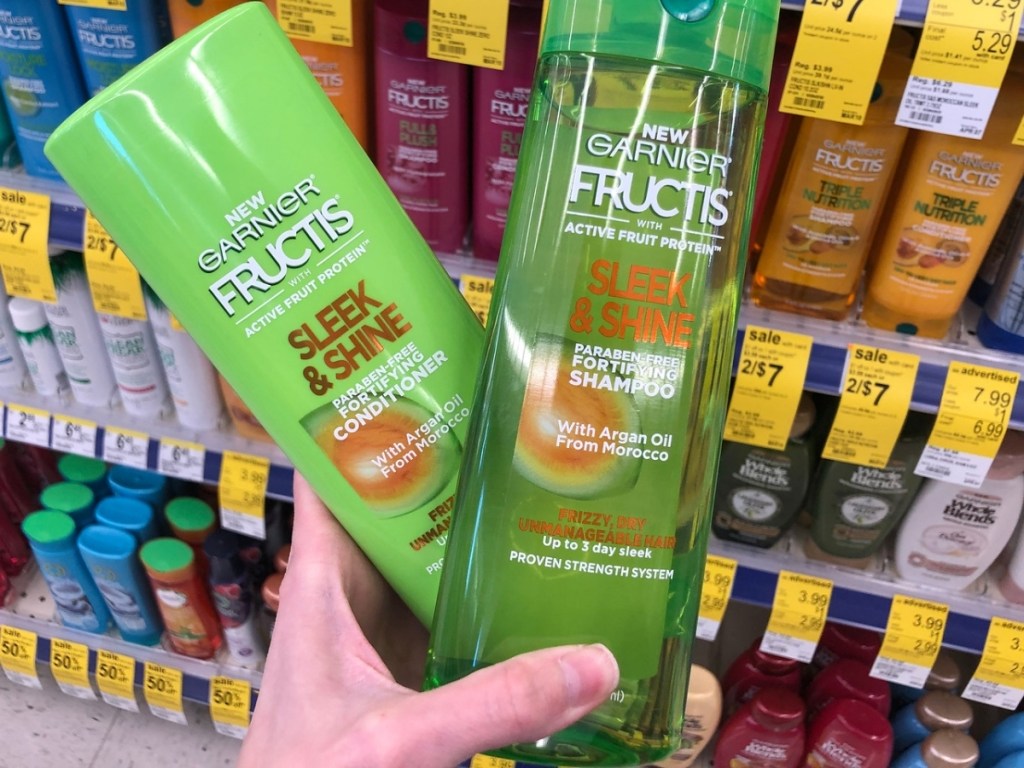 hand holding garnier shampoo and conditioner in store