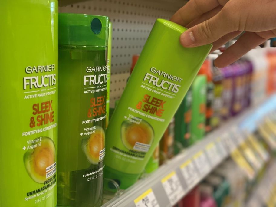 hand holding a bottle of Garnier Sleek & Shine