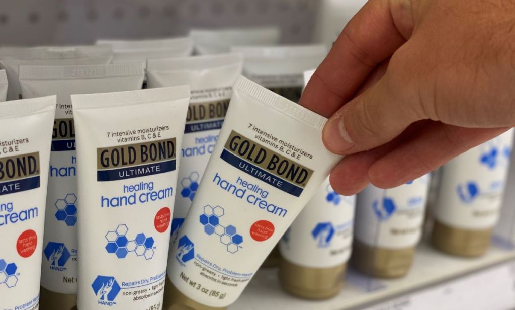 hand holding a Gold Bond Hand Cream