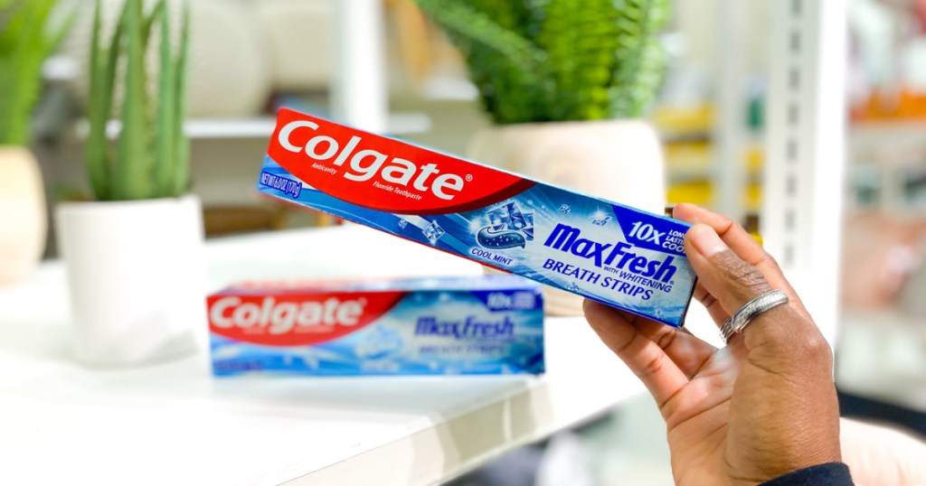 Hand holding Colgate Max Fresh toothpaste
