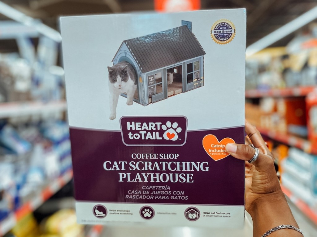 hand holding heart to tail cat scratching playhouse at aldi