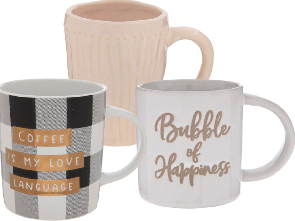 3 hobby lobby coffee mugs, one that says coffee is my love language, a plain beige one with texture and another that says bubble of happiness on it