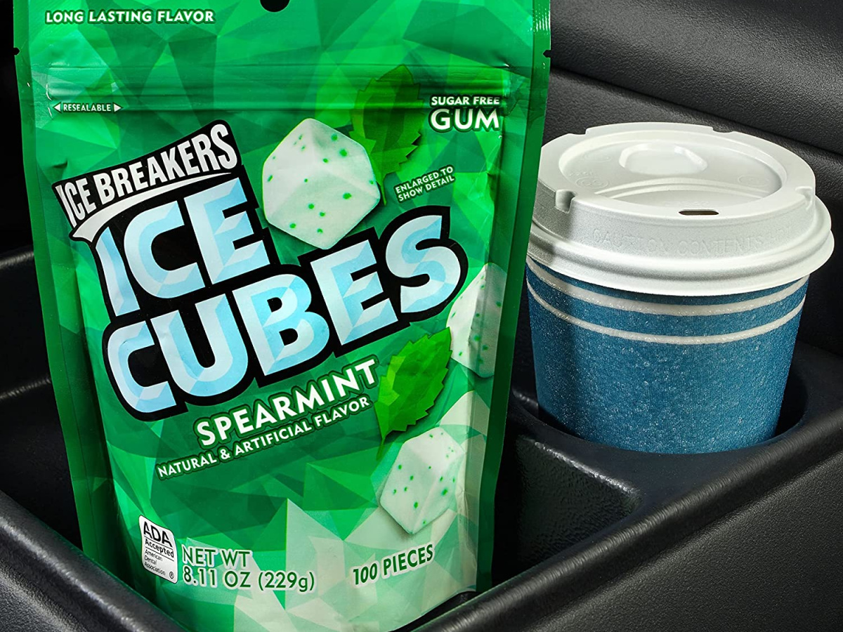 bag of spearmint gum cubes and blue coffee cup in car