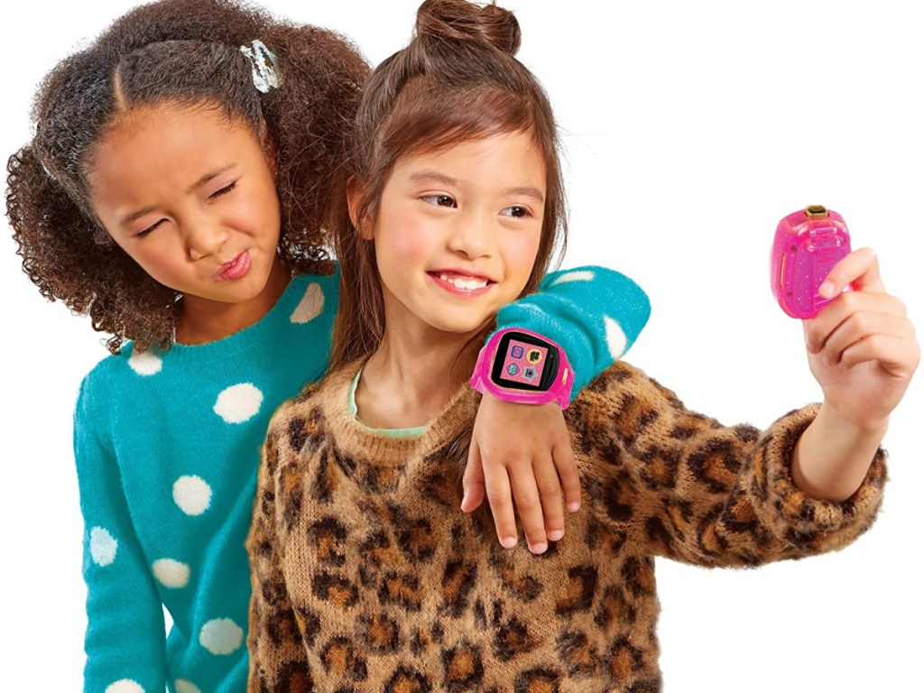 two little girls looking at pink watches on their hands
