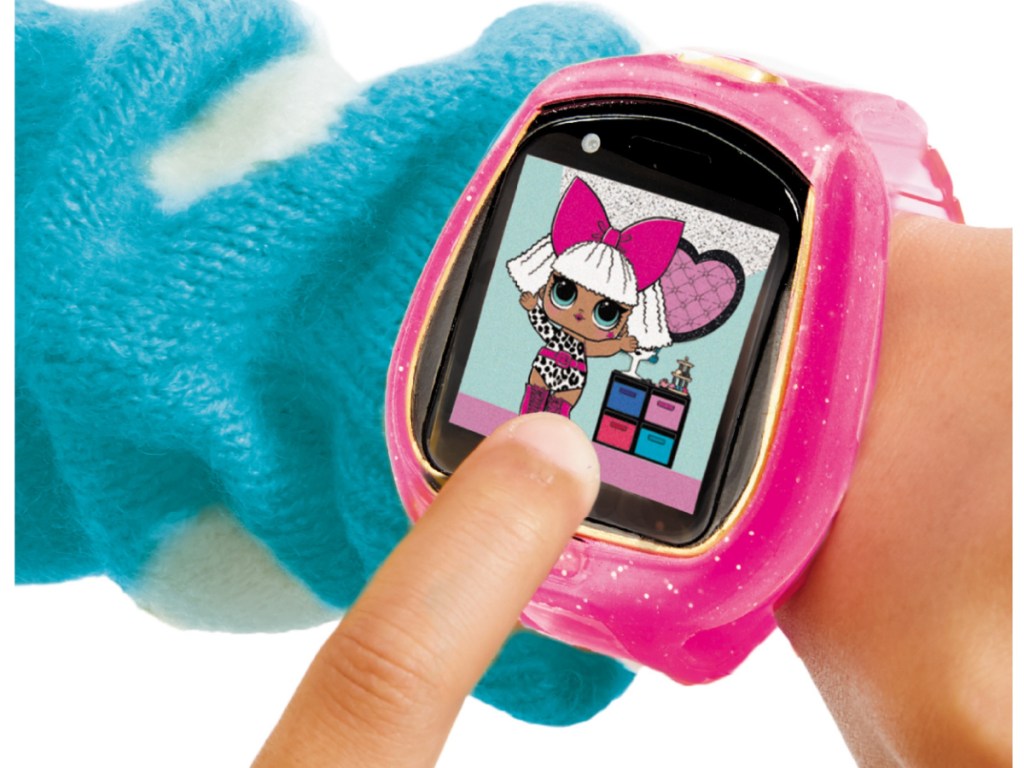 small hand wearing pink watch with doll characters on it