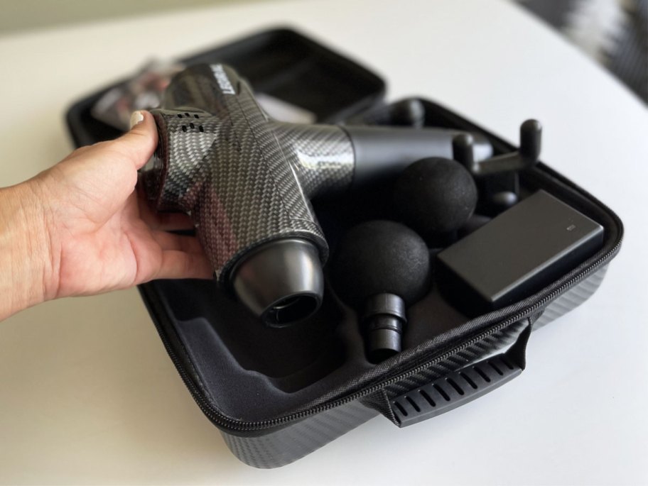 holding massage gun in carrying case
