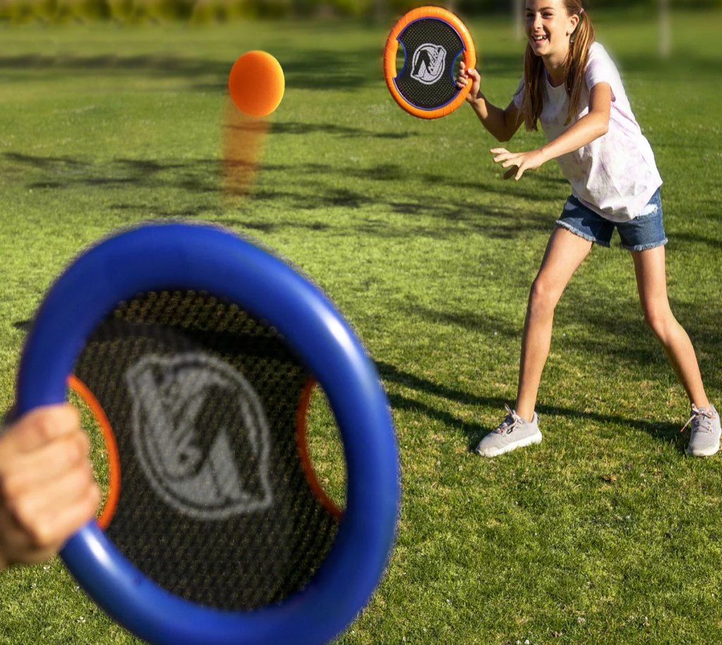 kids playing with paddle ball set outdoors