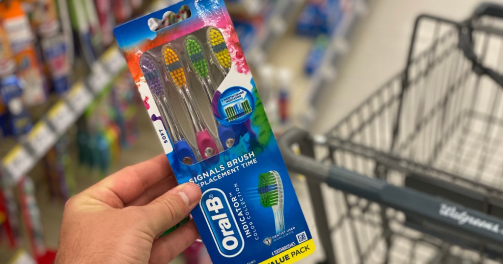 hand holding toothbrushes in package 