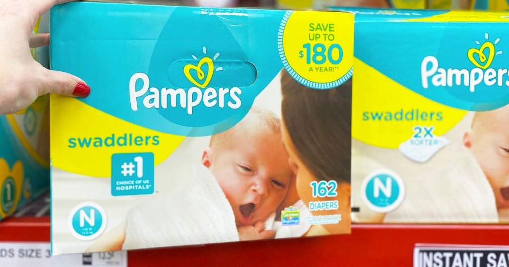 hand on box of pampers diapers on shelf at sam's club