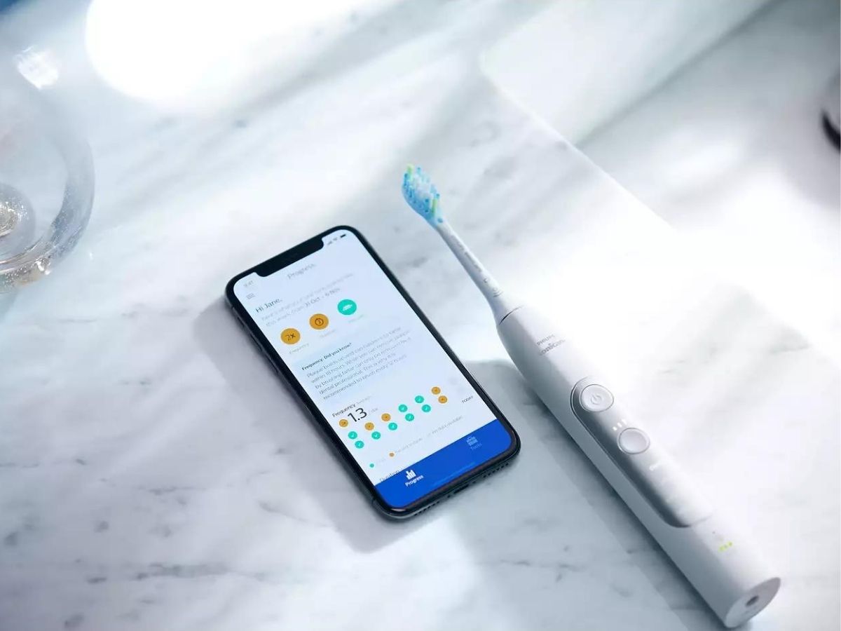white sonicare toothbrush and smartphone